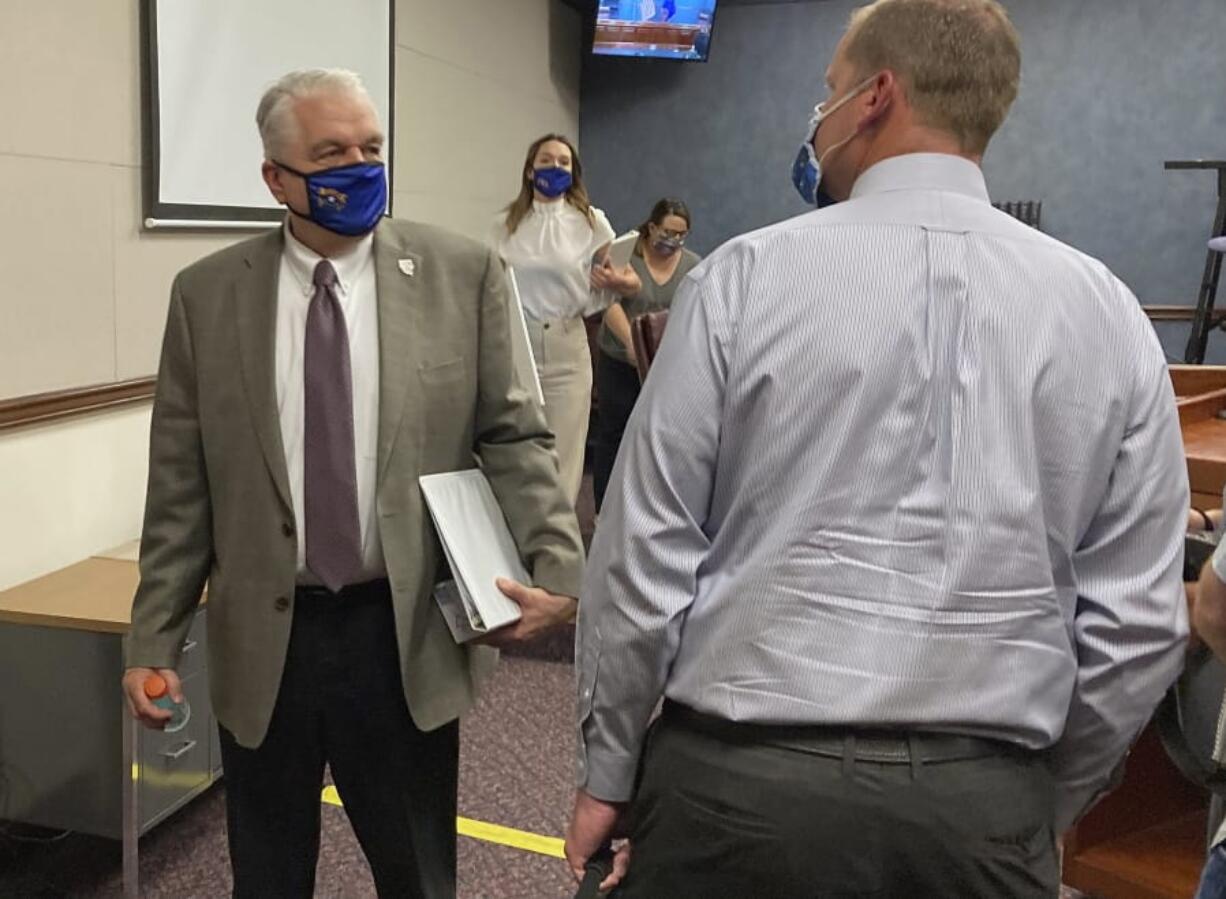 FILE - In this Wednesday, June 24, 2020, file photo, Nevada Gov. Steve Sisolak exits a news conference at the Nevada State Legislature in Carson City, Nev. Sisolak announced Nevada would join California, Washington and North Carolina in requiring individuals wear masks in public places to contain the spread of the coronavirus.