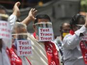 Activists of Communist Party of India Marxist display placards on face shields and shout slogans during a protest asking the state government to increase testing and free treatment for all COVID-19 patients in Hyderabad, India, Monday, June 29, 2020. Governments are stepping up testing and warily considering their next moves as the number of newly confirmed coronavirus cases surges in many countries. India reported more than 20,000 new infections on Monday.