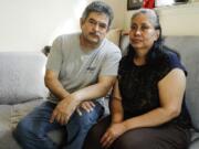 In this Thursday, June 4, 2020, photo, Francisco Flores, left, poses for a portrait with his wife Livia Herrera in New York. When his brother Crescencio Flores died of coronavirus in New York, his parents back in Mexico asked for one thing: that their son be sent home for burial. So far, his efforts have been in vain. &quot;I am trying to do this because my parents, 85 and 87 years old, live there,&quot; Francisco Flores said. &quot;They are rooted in their customs.