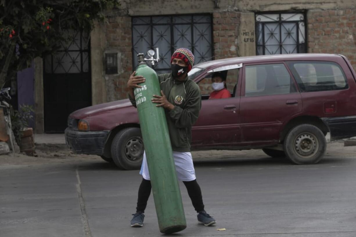 A man moves an empty oxygen cylinder in Callao, Peru, Wednesday 3, 2020. Long neglected hospitals in Peru and other parts of Latin America are reporting shortages of Oxygen as they confront the COVID-19 pandemic.