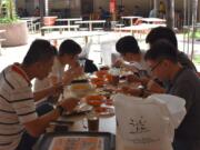 A group of five people have lunch together at the Newton Food Center Friday, June 19, 2020, in Singapore. Singaporeans can now wine and dine at restaurants, work out at gyms and get together with five people or less after most lockdown restrictions were lifted Friday.