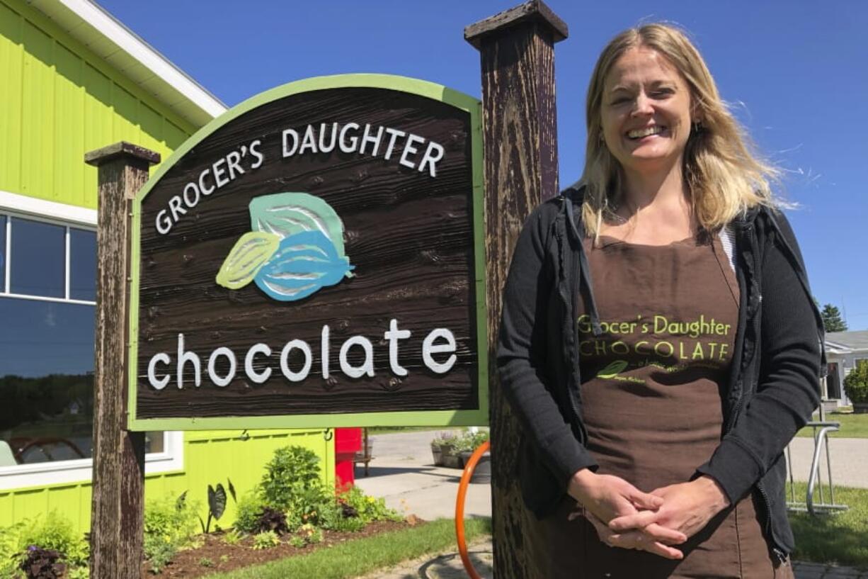 In this June 11, 2020 photo, Jody Hayden poses at the Grocer&#039;s Daughter chocolate shop which she owns with her husband in Empire, Mich, She said her family wears masks and keep their distance from others -- and will expect their customers to do the same when they open the doors to their shop, next Friday, June. 19. Even as states and metropolitan areas relax restrictions on social and economic life amid the ongoing coronavirus pandemic, a new poll finds that most Americans aren&#039;t ready to abandon behaviors that protect themselves and the people around them.