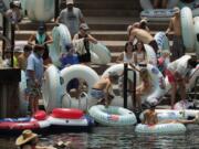 Tubers prepare to float the Comal River despite the recent spike in COVID-19 cases, Thursday, June 25, 2020, in New Braunfels, Texas. Texas Gov. Greg Abbott said Wednesday that the state is facing a &quot;massive outbreak&quot; in the coronavirus pandemic and that some new local restrictions may be needed to protect hospital space for new patients.