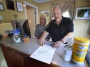 In this Wednesday, June 10, 2020, photo, Cod Cove Inn owners Ted and Jill Hugger show a draft of a compliance form that inn owners may be required to have out-of-state guests sign before being allowed to check in at their inn in Edgecomb, Maine. The form is part of the &quot;Keep Maine Healthy&quot; plan the state is proposing to help prevent the spread of the coronavirus. Residents of New Hampshire and Vermont would be exempt. (AP Photo/Robert F.