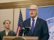 Washington Gov. Jay Inslee, right, talks to the media about the latest actions the state is taking to respond to the coronavirus outbreak, as then-Employment Security Department Commissioner Suzi LeVine looks on, Tuesday, March 10, in Olympia.