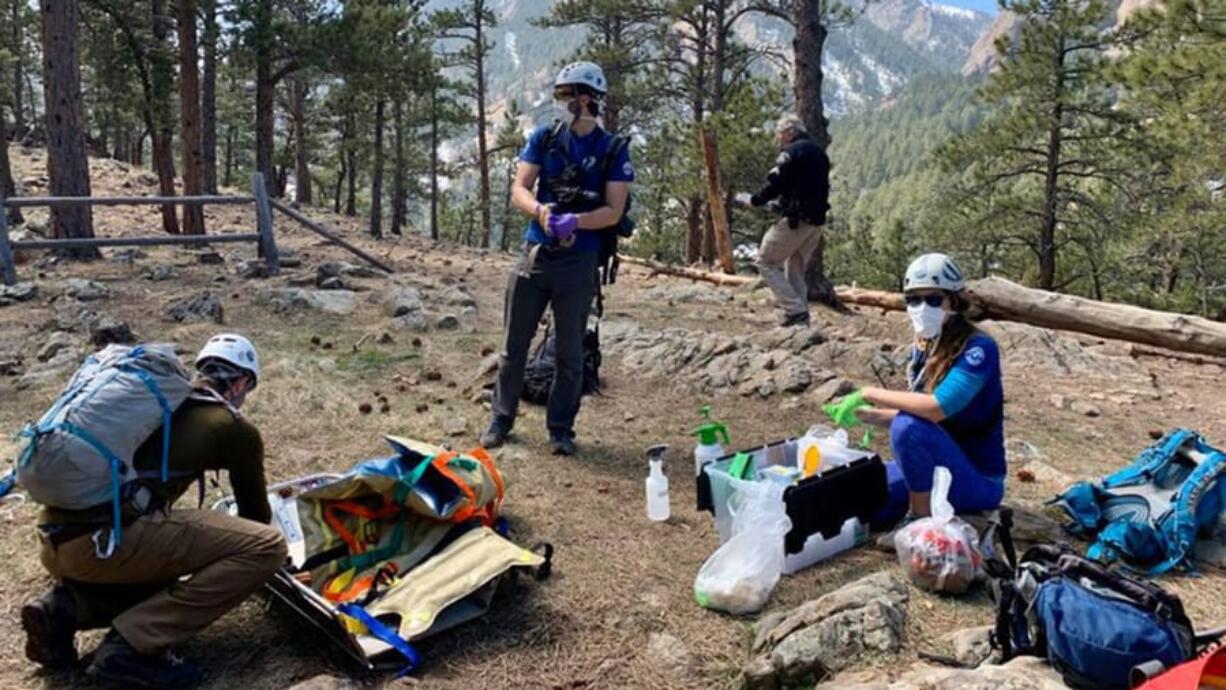 Members of the Rocky Mountain Rescue Group in Colorado wear masks and gloves during a mission earlier this year. The coronavirust pandemic is compounding many of the issues that have challenged search and rescue teams in recent years.