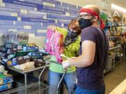 Volunteers Patti Colandrea and Stephen Klozik pack up orders for cats and dogs as the Care for Real pet food pantry reopens on July 2 in Edgewater, Ill.