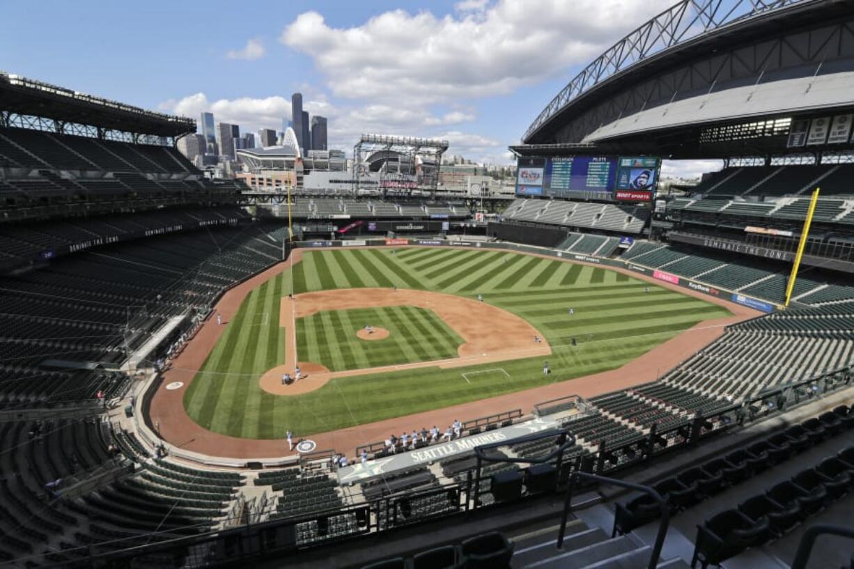 With the roof open, downtown Seattle visible in the distance and ballpark seats empty, the Seattle Mariners play an intrasquad baseball game during a &quot;summer camp&quot; workout Sunday, July 12, 2020. Even in a 60-game sprint season, this will not be the year that team comes to fruition. If anything, the truncated season may delay some of the Mariners rebuilding plans, but still with the optimistic hope the club begins turning the corner into contention in 2021.