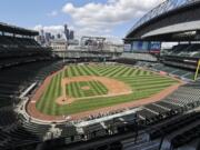 With the roof open, downtown Seattle visible in the distance and ballpark seats empty, the Seattle Mariners play an intrasquad baseball game during a &quot;summer camp&quot; workout Sunday, July 12, 2020. Even in a 60-game sprint season, this will not be the year that team comes to fruition. If anything, the truncated season may delay some of the Mariners rebuilding plans, but still with the optimistic hope the club begins turning the corner into contention in 2021.