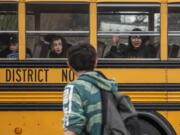 Students wave as their bus pulls away from Covington Middle School on March 13, the final day of in-person school for the 2019-2020 school year. Plans for fall at Clark County school districts are still unsettled.