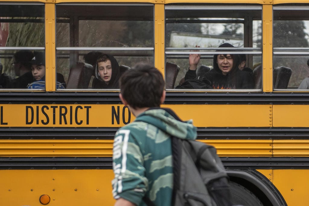 Students wave as their bus pulls away from Covington Middle School on March 13, the final day of in-person school for the 2019-2020 school year. Plans for fall at Clark County school districts are still unsettled.