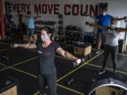 Kedie Sobeck of Los Angeles, Calif., center, works out at Burntown Fitness in east Vancouver. The studio reopened in June after Clark County entered Phase 2. It allow 5 people per class plus the instructor and has taped off sections to allow for social distancing.