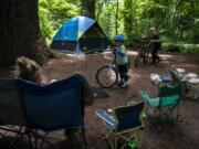 Jack Thompson, 5, of Kingston chats with his mom before taking off on his bike with a new friend from the adjacent campsite at Battle Ground Lake State Park in June. The campground is now open with some distancing restrictions in the group areas. Jack&#039;s mom, Leah, said their family had reservations at other campsites but they were canceled due to closures with the pandemic.