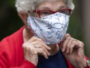 Esther Schrader adjusts her mask as she stands for a photo outside The Quarry in Vancouver.