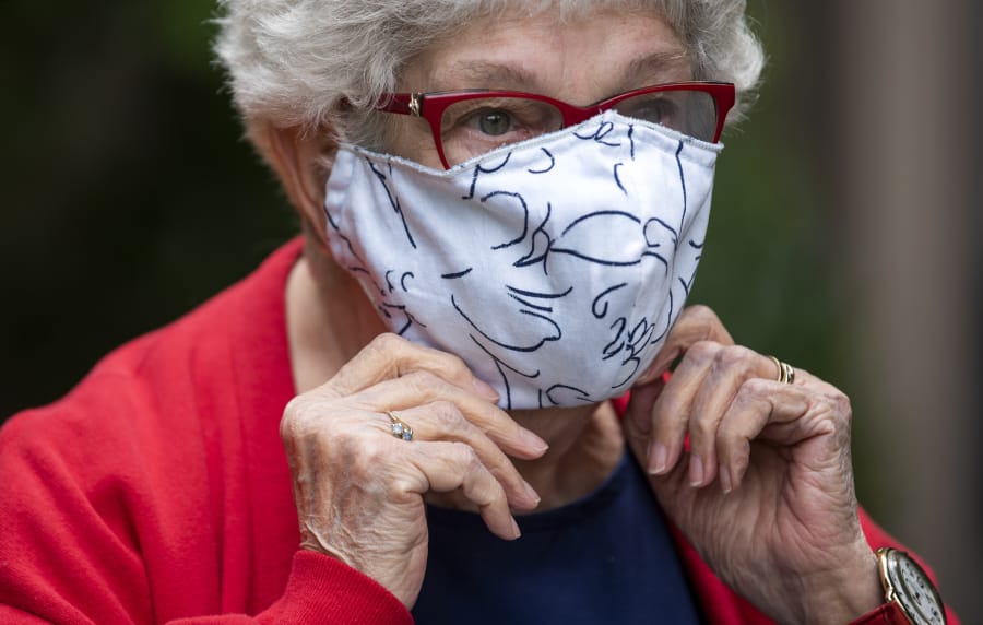 Esther Schrader adjusts her mask as she stands for a photo outside The Quarry in Vancouver.