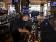 Steve Hilken, restaurant co-owner, makes drinks at Main Event&#039;s east location. During Phase 2 of reopening, restaurants must keep a 6-foot distance between tables. Main Event has eliminated bar seating and added one small table next to the bar.