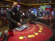 Gary Pfannes, an on-duty manager, demonstrates the use of a germicidal wand to sanitize casino chips in between use Wednesday at The Palace Casino in La Center. The Palace reopened Wednesday.