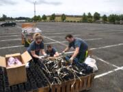 Western Display Fireworks crew member Alisa Williams, from left, pyrotechnician Reggie Edwards and lead pyrotechnician Chad Williams prepare fuses, fireworks and launchers in a parking lot at the Clark County Event Center at the Fairgrounds on Saturday. The no-audience show was to be broadcast live on Fox-12 TV for viewers to enjoy at home. Most Fourth of July fireworks events throughout the region, including the annual show at Fort Vancouver, were canceled this year due to the coronavirus pandemic.