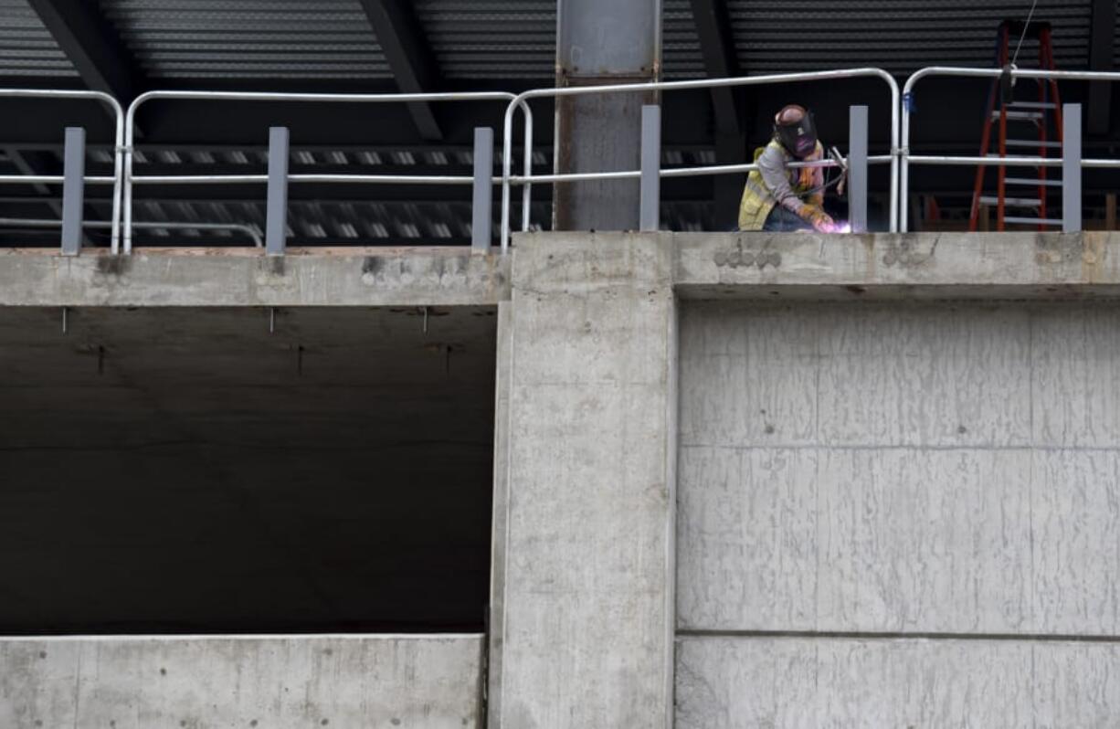 A worker lends a hand to the construction on the new Angelo Tower in Uptown Village on Wednesday morning. The project by the Al Angelo Co. will erect a six-story office tower on the site. Construction is one of the sectors that saw a decline in unemployment claims last week.