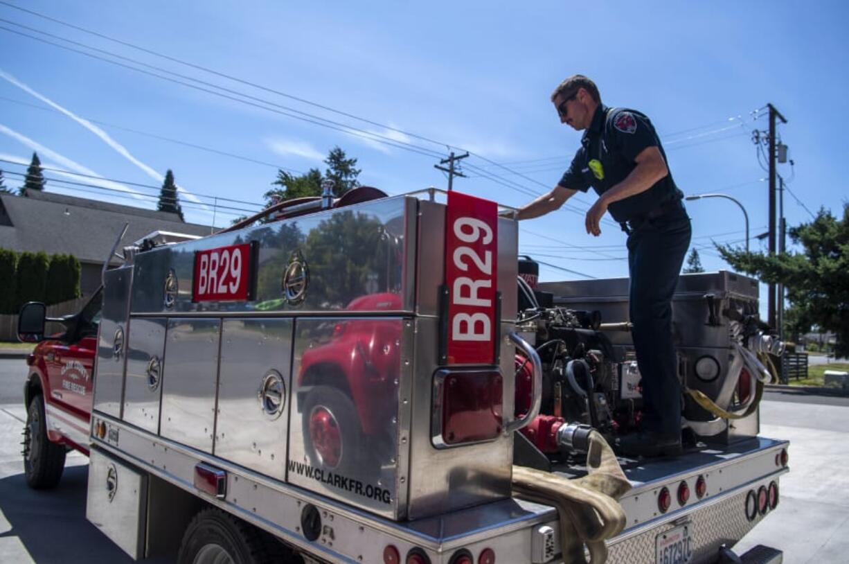 Clark County Fire &amp; Rescue firefighter Ian Fagan performs a routine check on a brush unit water pump Thursday at Station 29 in Woodland.