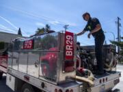 Clark County Fire &amp; Rescue firefighter Ian Fagan performs a routine check on a brush unit water pump Thursday at Station 29 in Woodland.