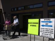 Kirsten Johnson of Vancouver, left, and her father, Ron, are in compliance with store and state policy while wearing protective face masks as they leave Chuck's Produce & Street Market in Salmon Creek with their groceries on Tuesday afternoon.