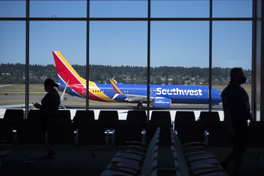 Travelers at Gate E10 wait to board a Southwest plane in the new Concourse E extension at Portland International Airport.