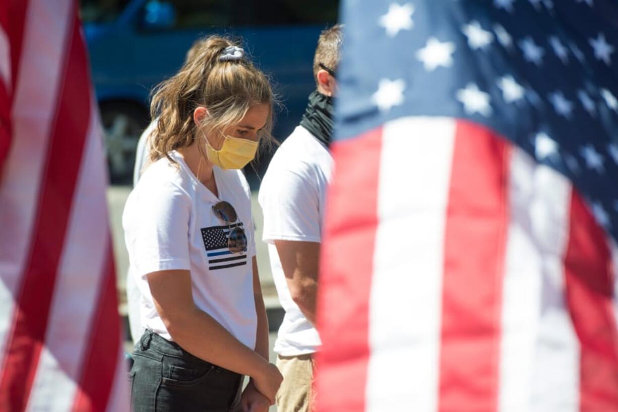 McKenna Babikoff of Battle Ground prays during a rally supporting police at Esther Short Park in downtown Vancouver on Saturday. The rally was part of a national movement called Bridge the Blue.