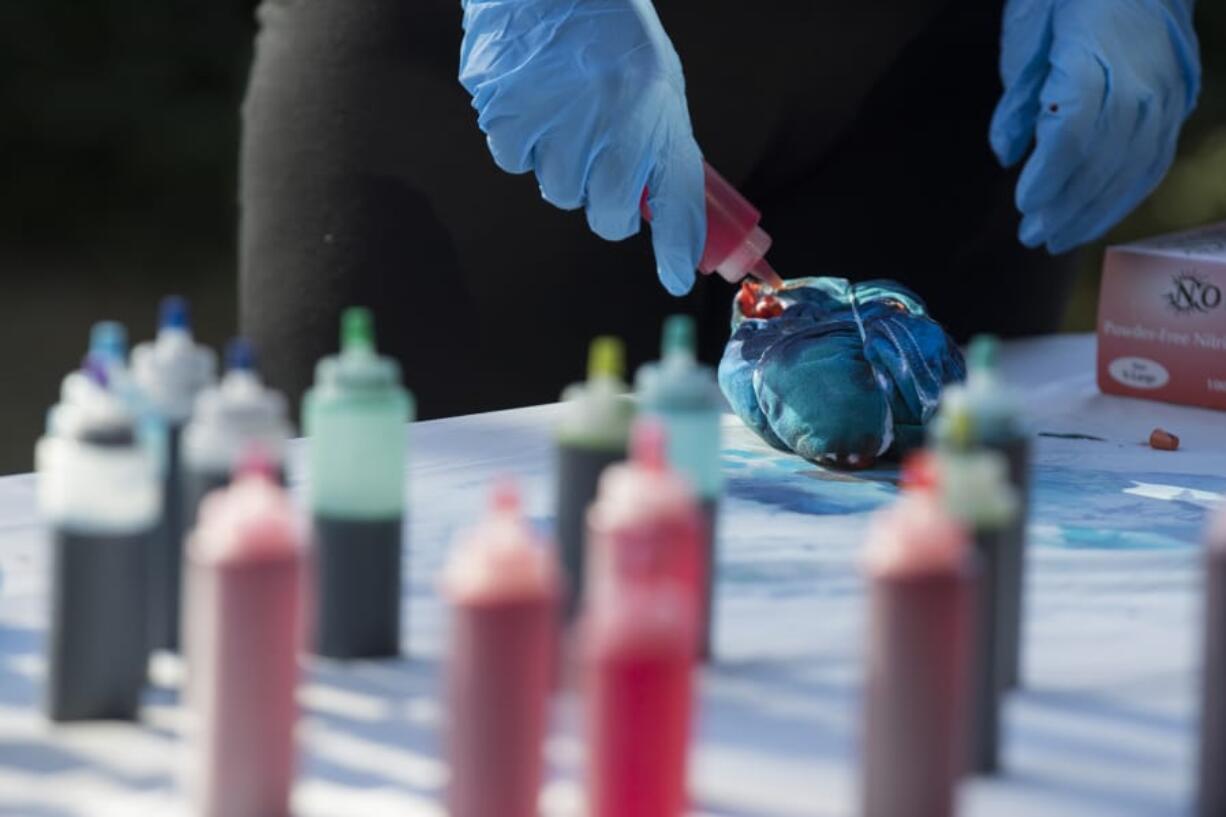 A participant adds extra color to her tie-dye shirt during the summer celebration at the YWCA on Tuesday.