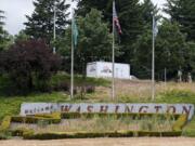 The &quot;Welcome to Washington&quot; sign that greets motorists as they enter Vancouver on Interstate 5, which usually features a colorful floral display, has become overgrown with weeds. The COVID-19 pandemic prevented the normal spring replanting of the sign&#039;s flower bed.