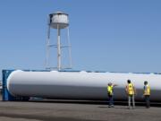 Longshore worker Jason Rasmussen, from left, talks with Zack Merrill, sales account manager for the Port of Vancouver, and Alex Strogen, the port's chief commercial officer, as they look over blades for wind turbines. The Port of Vancouver received the largest wind turbines blades ever to reach the West Coast on Monday.