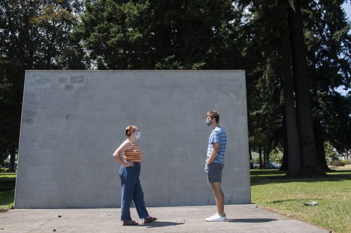 Camas High School rising seniors Kiana Gouveia, left, and Eli McMillan, both 17, pause to chat Tuesday afternoon at Crown Park. The pair had been writing messages on the wall in chalk to support the Black Lives Matter movement, but the murals have repeatedly been removed.