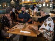 Bartender Derek Devlin, center, takes an order from Marliese Franklin and Jerry Ames during a soft-opening lunch at the second location of Amaro&#039;s Table in Hazel Dell. The restaurant&#039;s official opening is scheduled for Monday.