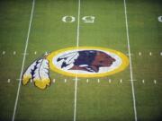 The Washington Redskins logo is shown on the FedEx Field grass in Landover, Md. The Washington Redskins are undergoing what the team calls a “thorough review” of the nickname.