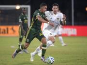 Portland Timbers midfielder Marvin Loria (44) controls the ball in front of LA Galaxy midfielder Sacha Kljestan during the first half of an MLS soccer match Monday, July 13, 2020, in Kissimmee, Fla. (AP Photo/Phelan M.