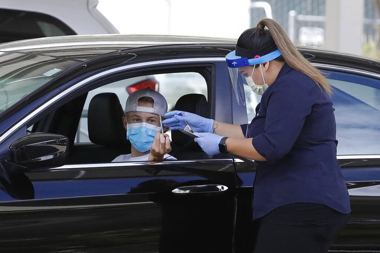 A health care worker takes information from a person at a Covid-19 testing center on Tuesday, July 21, 2020, in Pleasanton, Calif.