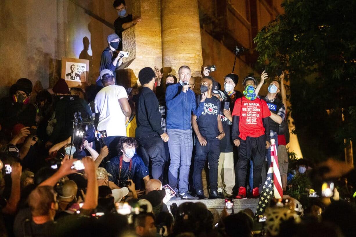 Portland Mayor Ted Wheeler speaks to Black Lives Matter protesters on Wednesday, July 22, 2020, in Portland, Ore. Late Wednesday Wheeler joined protesters at the front of the crowd and was hit with chemical irritants several times by federal officers dispersing demonstrators.