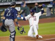 Houston Astros' Yuli Gurriel (10) scores as Seattle Mariners catcher Austin Nola looks on during the seventh inning of a baseball game Friday, July 24, 2020, in Houston. (AP Photo/David J.