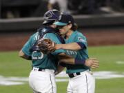 Seattle Mariners closing pitcher Taylor Williams, right, embraces catcher Austin Nola after the team beat the Oakland Athletics in a baseball game during the Mariners home opener Friday, July 31, 2020, in Seattle.