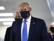 President Donald Trump wears a mask as he walks down the hallway during his visit to Walter Reed National Military Medical Center in Bethesda, Md., Saturday, July 11, 2020.