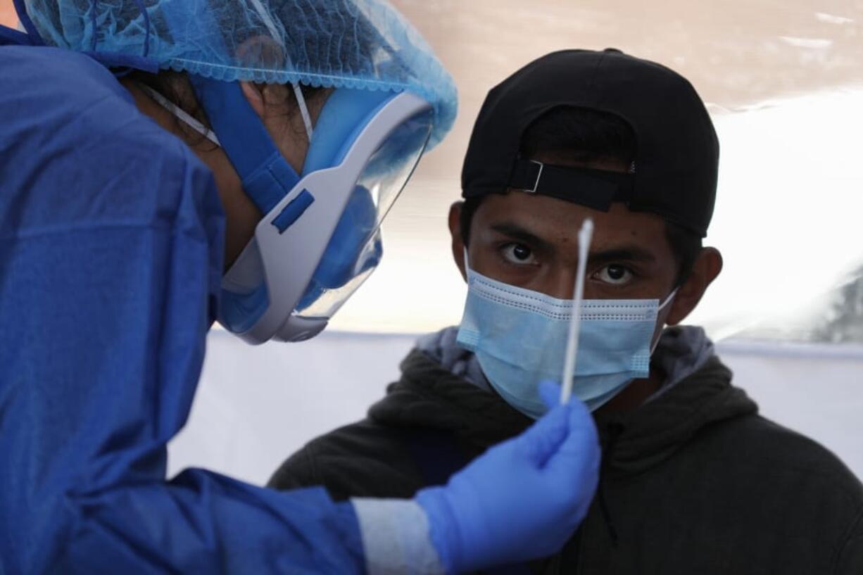 Dr. Diana Pacheco explains to a patient that she will collect nasal and throat swabs, during walk-up COVID-19 testing in a mobile diagnostic tent, in San Gregorio Atlapulco in the Xochimilco district of Mexico City, Friday, July 24, 2020.