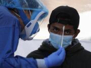 Dr. Diana Pacheco explains to a patient that she will collect nasal and throat swabs, during walk-up COVID-19 testing in a mobile diagnostic tent, in San Gregorio Atlapulco in the Xochimilco district of Mexico City, Friday, July 24, 2020.