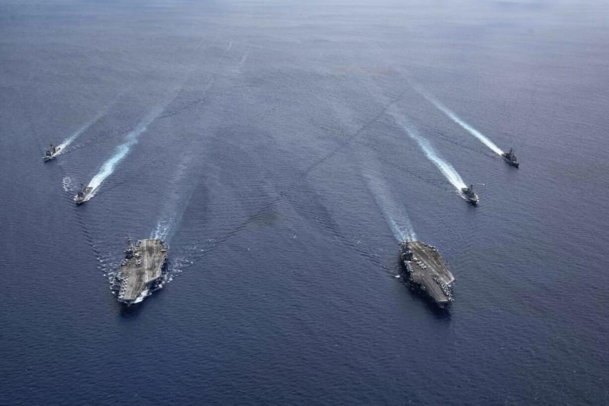 In this photo provided by U.S. Navy, the USS Ronald Reagan (CVN 76) and USS Nimitz (CVN 68) Carrier Strike Groups steam in formation, in the South China Sea, Monday, July 6, 2020. China on Monday, July 6, accused the U.S. of flexing its military muscles in the South China Sea by conducting joint exercises with two U.S. aircraft carrier groups in the strategic waterway.(Mass Communication Specialist 3rd Class Jason Tarleton/U.S. Navy via AP) (Mass Communication Specialist 3rd Class Jason Tarleton/U.S.