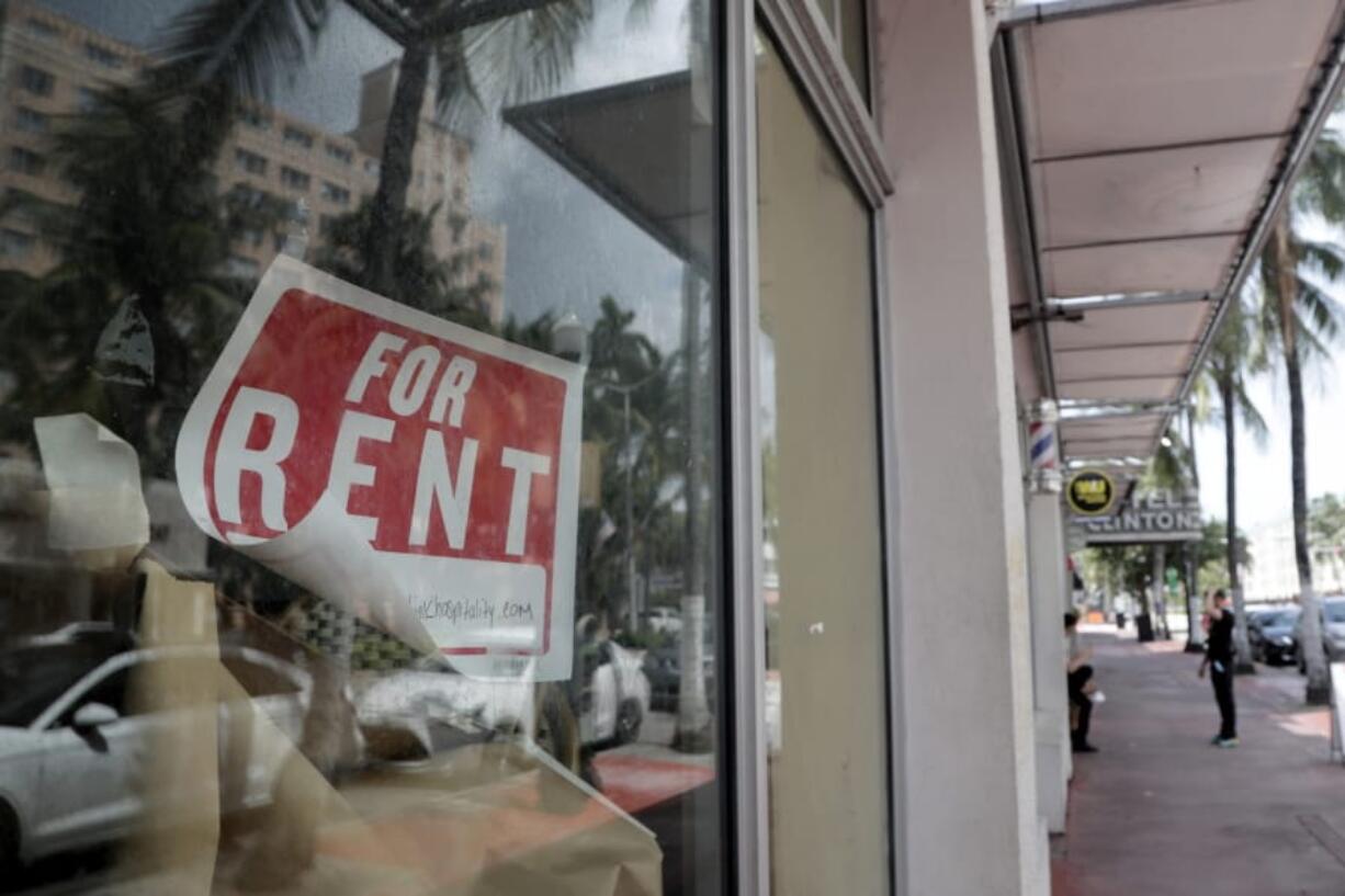 FILE - In this July 13, 2020 file photo, a For Rent sign hangs on a closed shop during the coronavirus pandemic in Miami Beach, Fla.  Having endured what was surely a record-shattering slump last quarter, the U.S. economy faces a dim outlook as a resurgent coronavirus intensifies doubts about the likelihood of any sustained recovery the rest of the year.