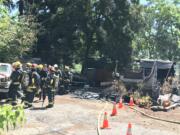 Firefighters gather after extinguishing a fire at a mobile home along Evergreen Boulevard.