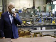 FILE - In this July 9, 2020, file photo Democratic presidential candidate, former Vice President Joe Biden adjusts his mask during a tour of McGregor Industries, a metal fabricating facility in Dunmore, Pa. Biden is pledging to define his presidency by a sweeping economic agenda beyond anything Americans have seen since the Great Depression and the industrial mobilization for World War II.