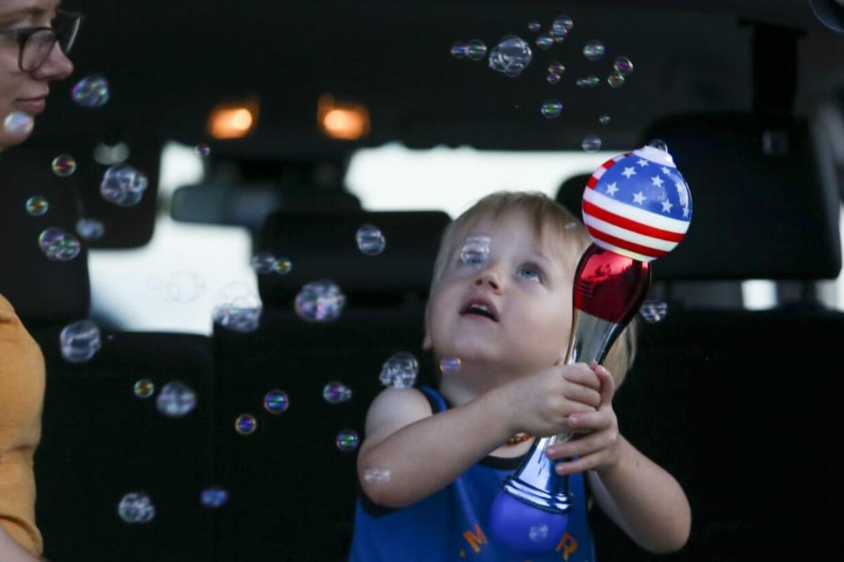 Brittani Scott watches her son, Cooper Scott, 2, play with bubbles while waiting to see a display of fireworks at Nathan Benderson Park, on Friday, July 3, 2020, in Sarasota, Florida.