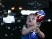 Brittani Scott watches her son, Cooper Scott, 2, play with bubbles while waiting to see a display of fireworks at Nathan Benderson Park, on Friday, July 3, 2020, in Sarasota, Florida.