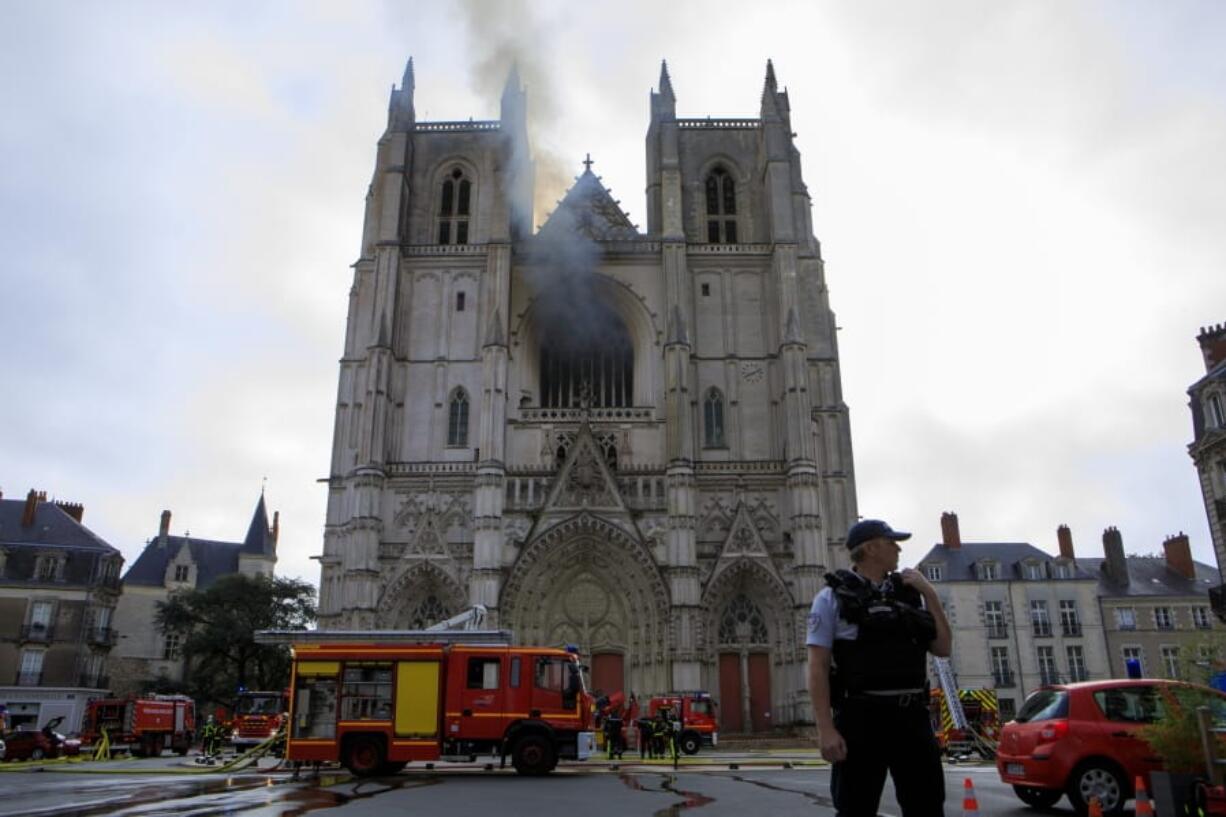 Fire fighters brigade work to extinguish the blaze at the Gothic St. Peter and St. Paul Cathedral, in Nantes, western France, Saturday, July 18, 2020. The fire broke, shattering stained glass windows and sending black smoke spewing from between its two towers of the 15th century, which also suffered a serious fire in 1972. The fire is bringing back memories of the devastating blaze in Notre Dame Cathedral in Paris last year that destroyed its roof and collapsed its spire and threatened to topple the medieval monument.