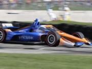 IndyCar driver Scott Dixon (9) is a blur of speed as he exits Turn 5 during the REV Group Grand Prix on Saturday at Elkhart Lake, Wis. Dixon went on to win the event. (Gary C.